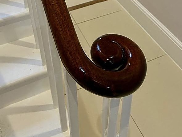 A hand-polished mahogany handrail volute