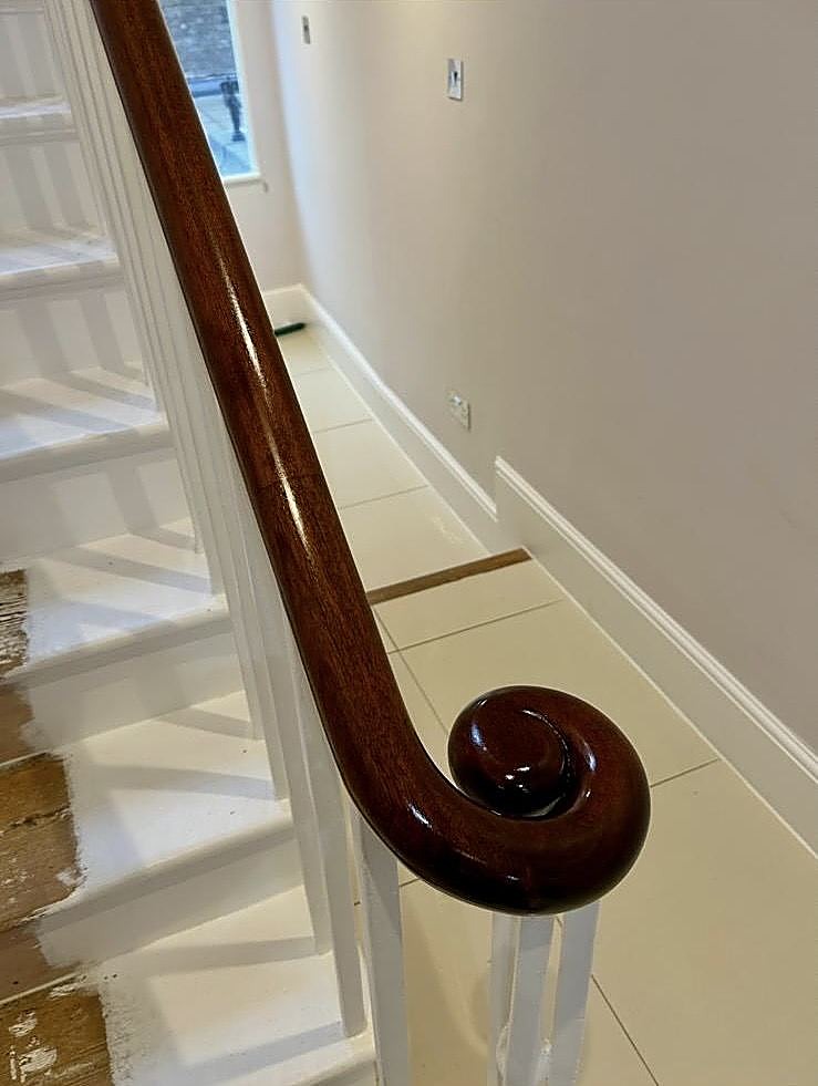 A hand-polished mahogany handrail volute