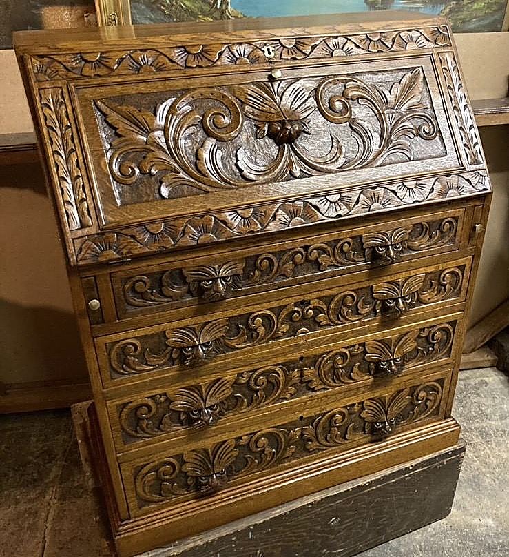 A carved oak bureau, restored
